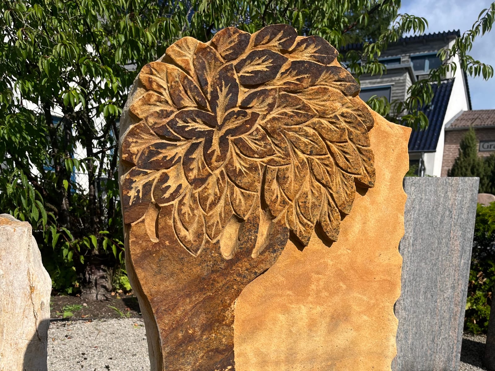 Liegestein mit von Hand gemeißeltem Blattornament